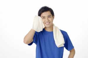 運動して顔の汗拭く男